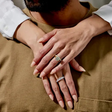 Hand with engagement ring and hand with wedding band